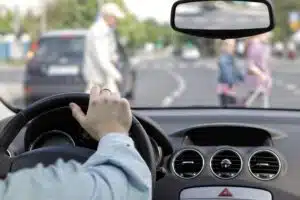 Person driving toward pedestrians crossing the street