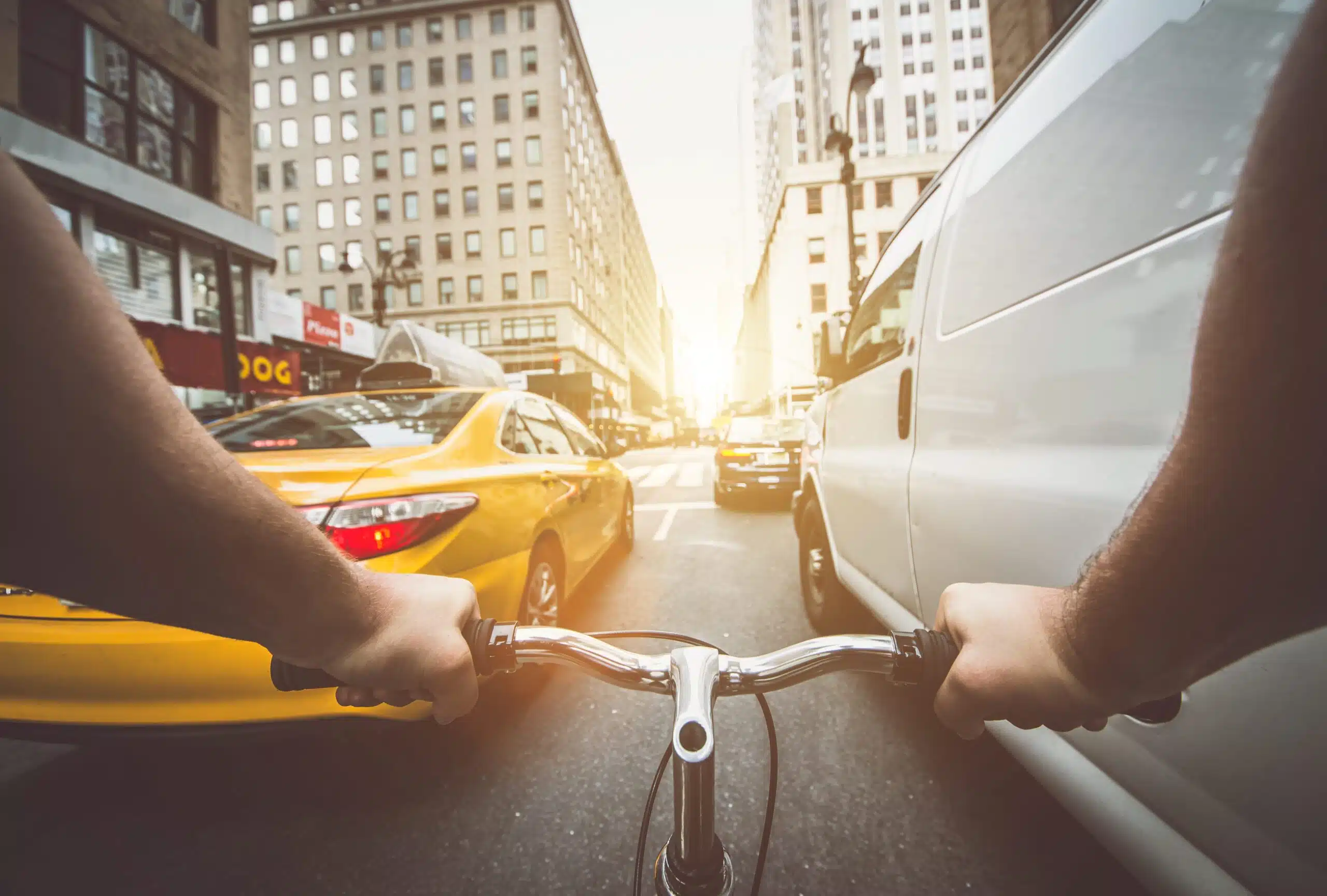 First-person view of bicyclist steering through space between cars in heavy traffic