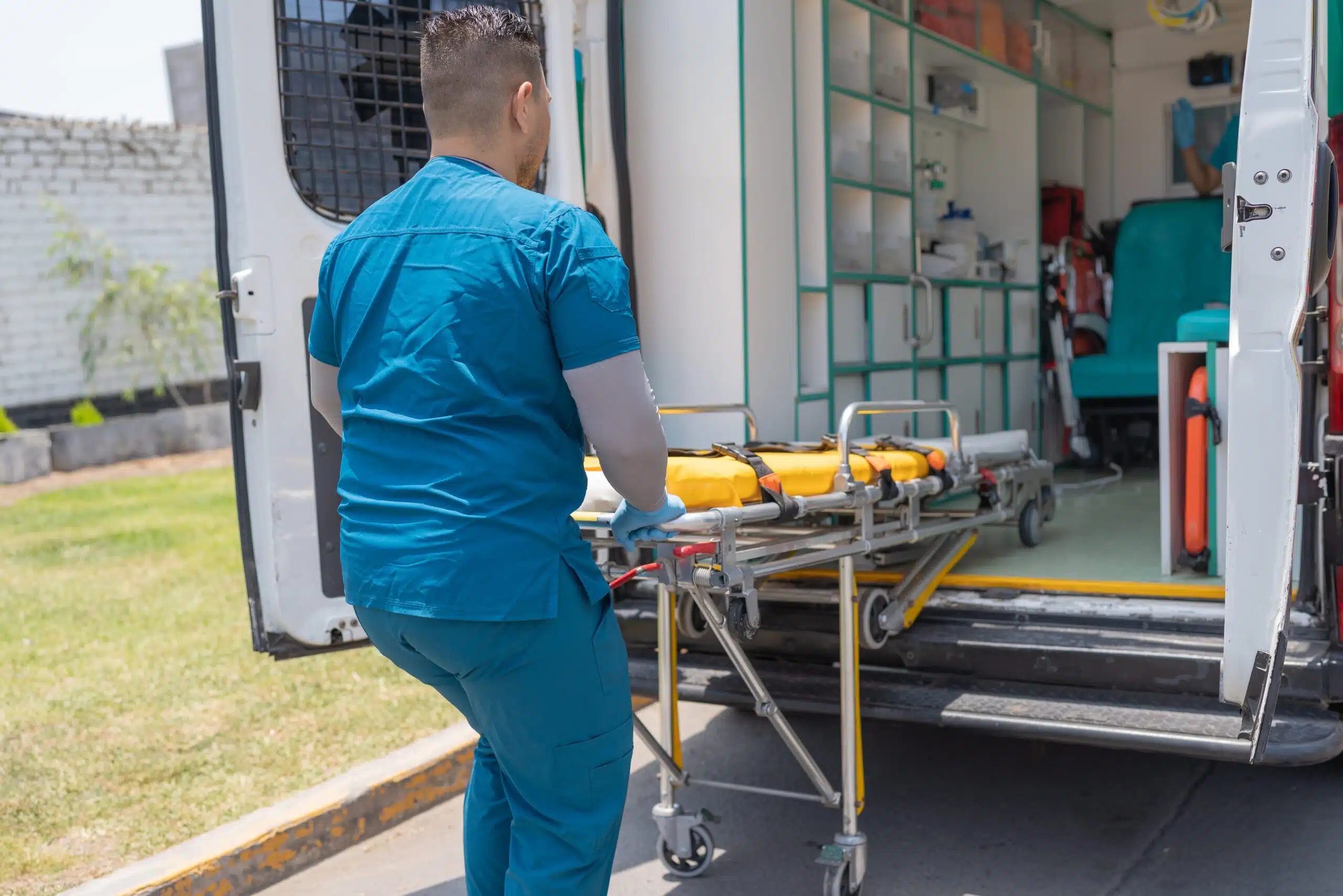 Medical personnel pulling a stretcher out of an ambulance