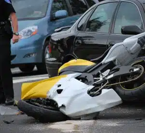 Motorcycle on its side in the street after a serious accident; police are on the scene