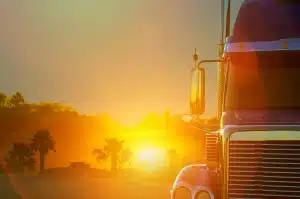 a semi truck driving through Florida at dawn