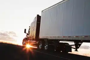 semi truck driving at sunset